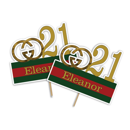 Gucci inspired personalized cake toppers in gold and green red stripe design flat lay on table