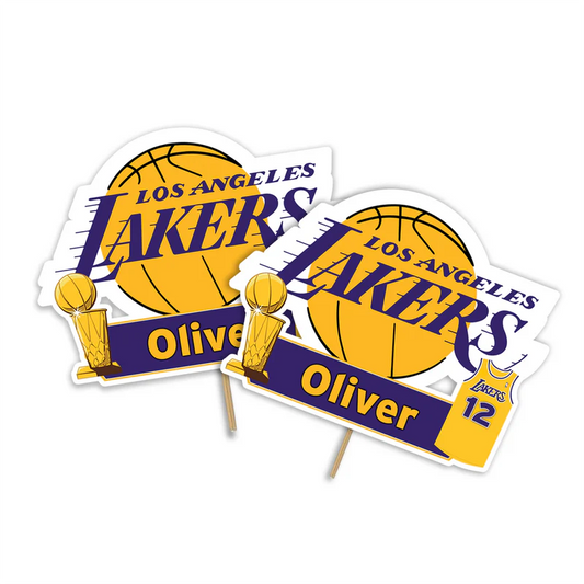 LA Lakers cake toppers with basketball graphics and custom text on frosted cake, flat lay style