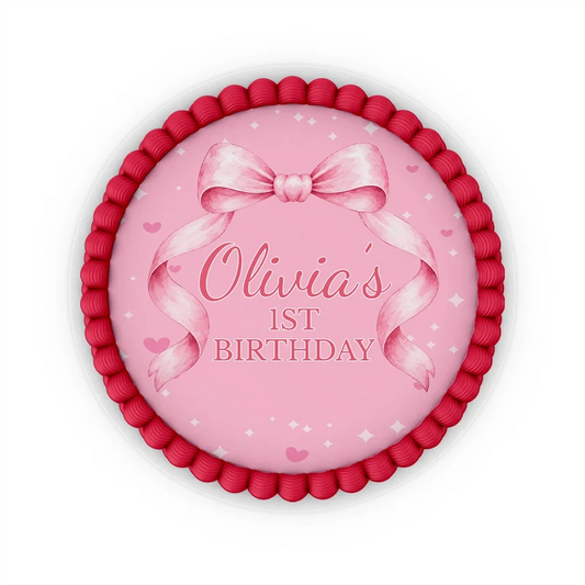 Pink Bow edible icing cake images with soft pink ribbon accents placed on a frosted round cake