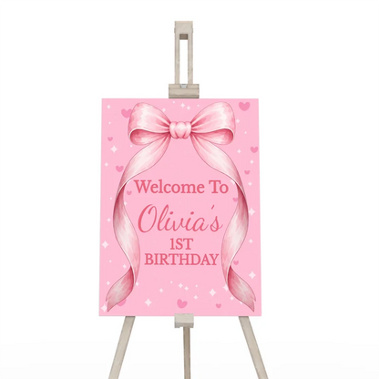 Pink Bow welcome sign displaying a pastel greeting layout on a wooden display easel