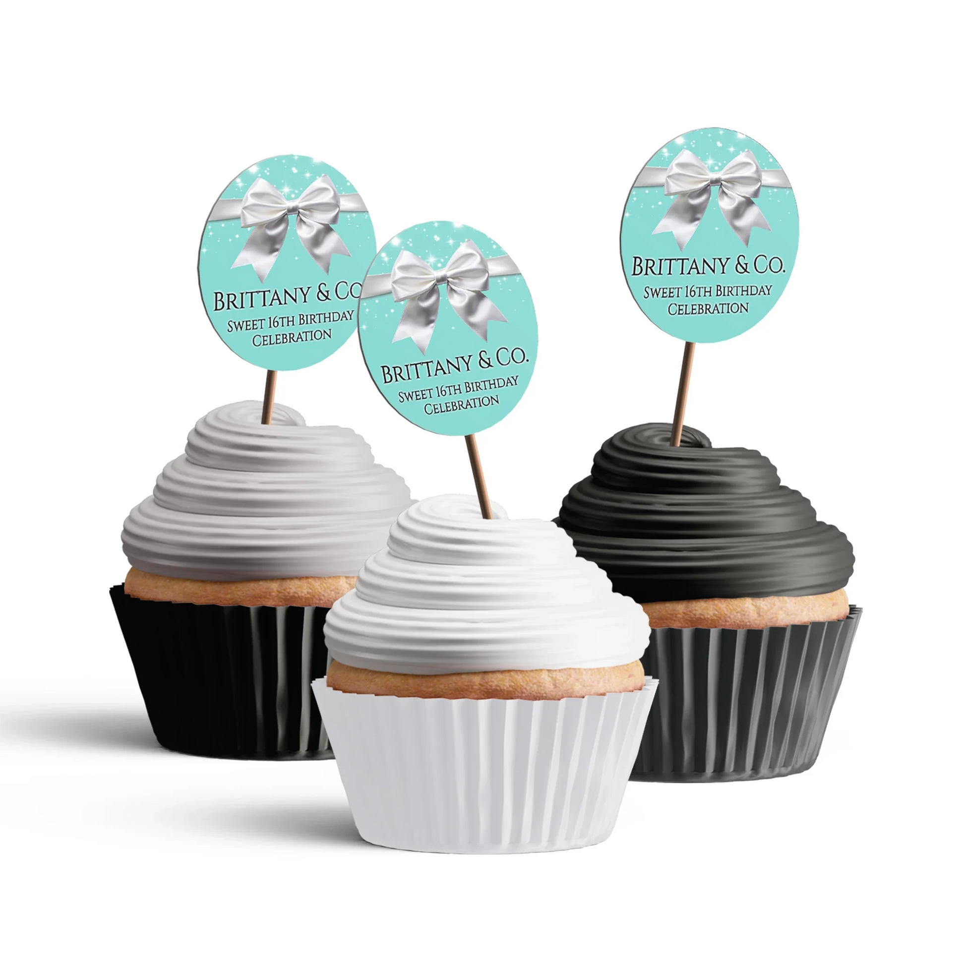Tiffany & CO cupcake toppers with small white bows and teal blue circular frames displayed in a flat lay arrangement